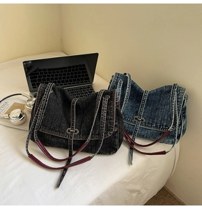 Detail of vintage denim tote bags in blue and black with leather straps and metal buckle