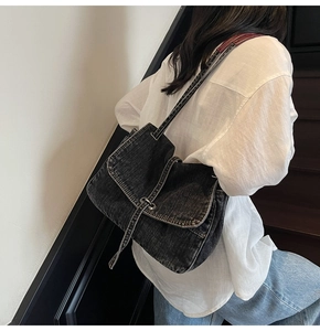 Detail of vintage washed denim crossbody bag in dark gray with adjustable shoulder strap