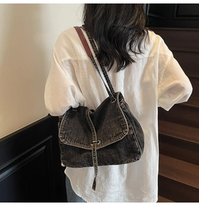 Lifestyle view of vintage washed denim shoulder bag styled with white shirt and staircase