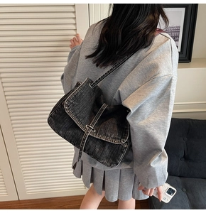 Detailed side view of oversized vintage denim messenger bag with adjustable strap