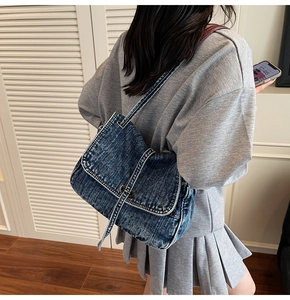 Détail du sac cabas vintage en denim avec surpiqûres blanches et fini délavé
