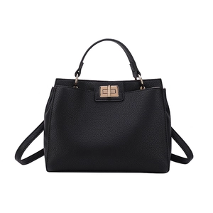 Retro black leather tote bag with gold twist lock and adjustable shoulder strap on white base