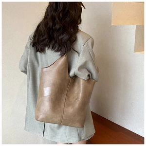 Vue détaillée d'un grand sac cabas camel montrant les coutures et la taille sur un modèle