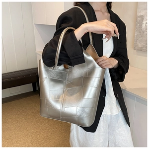 Détail d'un sac cabas argenté avec patchwork géométrique et poignées rondes en métal