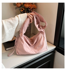 Detailed view of pink nylon tote bag showing soft twill texture and large capacity