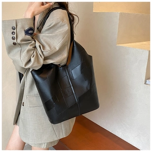 Gros plan sur un cabas en cuir noir avec un design géométrique original en patchwork