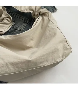 Detail showing the pleated drawstring canvas bag fabric on a blue denim jacket