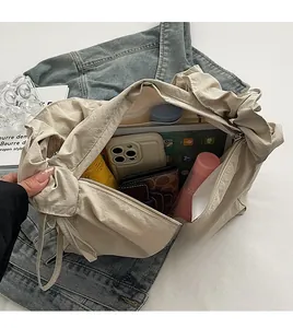 Spacious interior of beige drawstring tote showing storage for tablet, umbrella and wallet