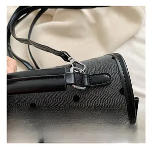 Detail view of silver metal hook and black leather strap on gray polka dot bag
