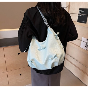 Detail of light blue wrinkled leather tote bag with stylish bows and lacing