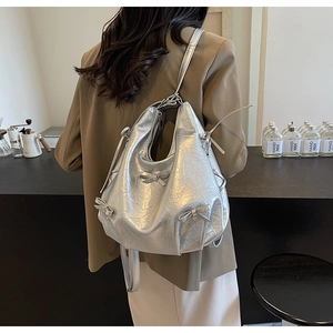 Close-up of metallic silver backpack with stylish bow details and crinkle texture