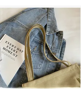 Close-up of beige canvas tote bag with reinforced handles and minimalist aesthetic