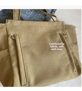Detail of soft khaki canvas tote bag showing high-density fabric texture and side pocket