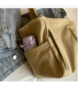 Detail of khaki canvas tote bag featuring side umbrella pocket and durable stitching
