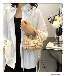Detail of beige quilted dumpling bag texture and puff soft fabric shoulder strap