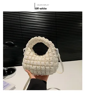 Détail du sac cabas matelassé crème montrant la texture plissée et la bandoulière