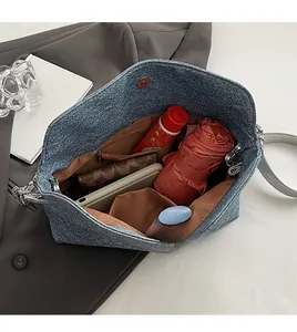 Macro view of blue denim hobo bag interior showing spacious storage and multi-functional pockets