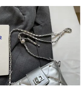 Detail der silbernen Stepptasche mit Kettenriemen und verstellbarer Metallkugel