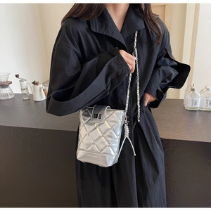 Nahaufnahme einer silbernen Stepptasche mit glänzendem Metallic-Finish und Kettenriemen