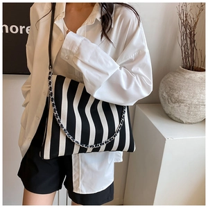 Detail of large canvas tote bag with black and white stripes and metal chain strap