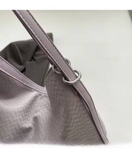 Detail of purple woven texture shoulder bag with bright silver metal ring hardware