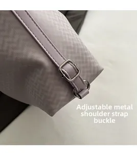 Detail of adjustable silver buckle and purple twill strap on a casual shoulder bag