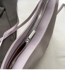 Detailed macro of smooth silver metal zipper and woven texture on lavender tote bag