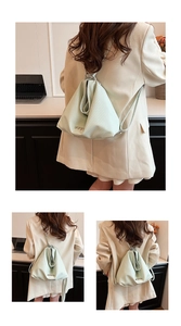 Detail of mint green woven leather backpack featuring four silver heart-shaped metal accents