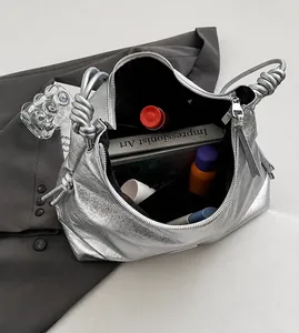 Close-up of the silver metallic pleated tote bag featuring a knotted handle and large interior
