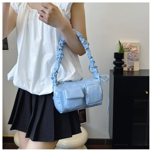 Detailed view of light blue PU handbag featuring a unique scrunchie handle and double pockets