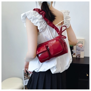 Detail of burgundy PU leather handbag with large bow and ruched wide shoulder strap