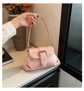 Détail du sac bandoulière rose brillant avec boucle cœur et côtés plissés