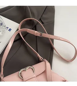 Détail du sac à main rose en simili cuir avec boucle coeur argentée et bandoulière