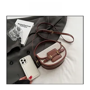 Close-up of saddle bag with brown leather and canvas texture near a smartphone