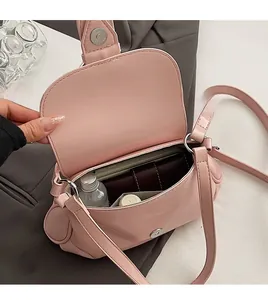 Vue intérieure montrant la capacité du sac selle rose avec téléphone et portefeuille