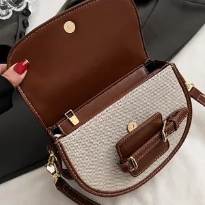 Detail shot of the golden magnetic clasp and textured fabric on the brown saddle bag