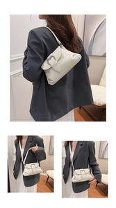 Gros plan du sac à bandoulière blanc crème avec boucle métallique élégante en cœur