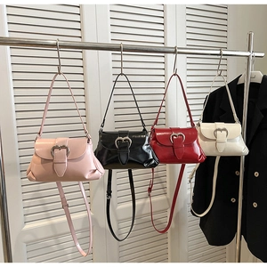 Détail de quatre sacs à main en cuir verni avec boucles en cœur dans une variété de couleurs