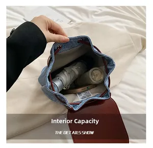 Internal capacity of denim backpack showing space for a water bottle, phone, and umbrella