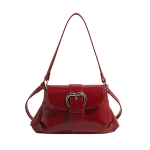 Sac à bandoulière rouge brillant minimaliste avec boucle en cœur et design accordéon