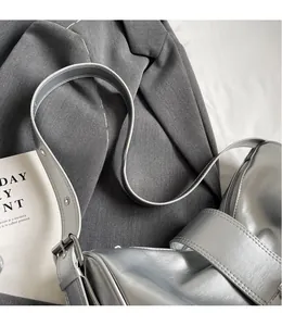 Detail of silver metallic handbag showing the smooth zipper and adjustable eyelet strap