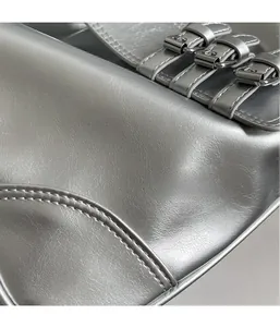 Detail of silver metallic PU leather bag with three adjustable metal buckle straps