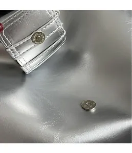 Detailed close-up of metallic silver leather texture and premium magnetic snap closure