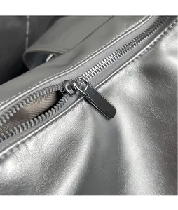 Detail of silver textured leather bag featuring high-quality metal zipper and smooth slider