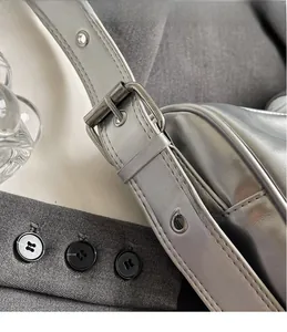 Close-up of the silver buckle and meticulous stitching on a metallic shoulder bag