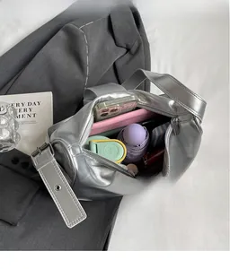 Spacious interior of silver metallic cylinder bag showing daily essentials and wide strap