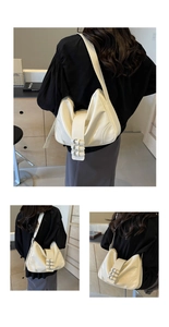 Close-up of cream underarm bag featuring three decorative silver buckles on smooth faux leather