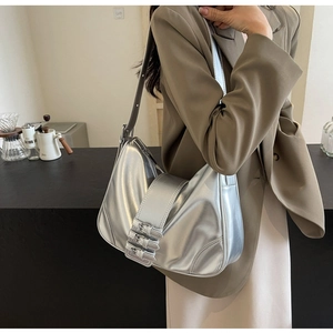 Detail of silver metallic hobo bag with triple buckle straps on khaki blazer