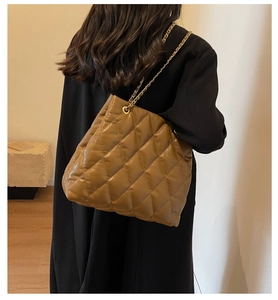 Brown quilted chain shoulder bag shown on model for size perspective and style