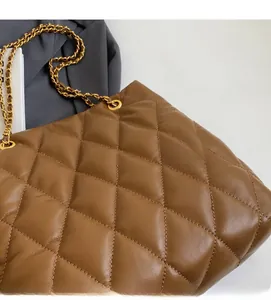 Detailed close-up of brown quilted rhombus texture and gold chain strap on shoulder bag